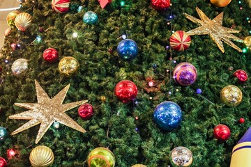 Christmas tree background and Christmas decorations. Colorful balls and garland on green fir. Happy New Year and Xmas theme