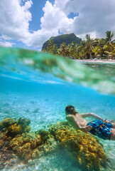 Diving teenage boy snorkeling over the coral reefs underwater photo in the clean turquoise lagoon...