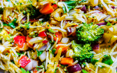 Vegetable dish with tomatoes rice onions beans on white plate.