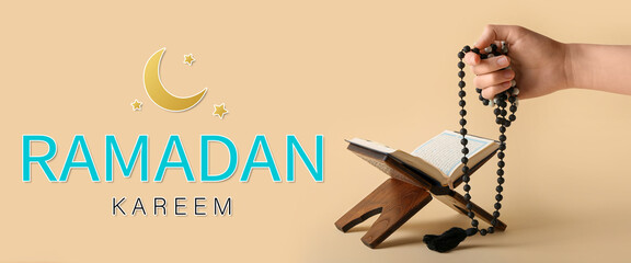 Hand with tasbih and Koran on beige background. Greeting card for Ramadan