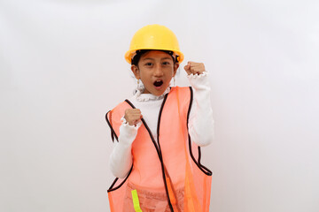 Successful Asian little girl in the construction helmet as an engineer standing with clenched or fist hands. Isolated on white