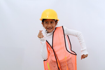 Cute Asian little girl in the construction helmet as an engineer dancing while looking sideways. Isolated on white
