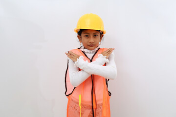 Asian little girl in the construction helmet as an engineer standing with crossed hands. Isolated on white