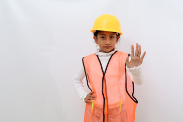 Asian little girl in the construction helmet as an engineer standing while making stop hand gesture. Isolated on white