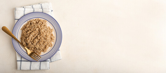 Plate of tasty boiled quinoa on light background with space for text