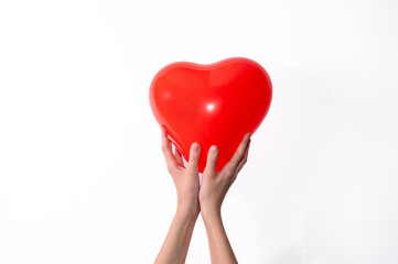 Hands holding red heart against white background