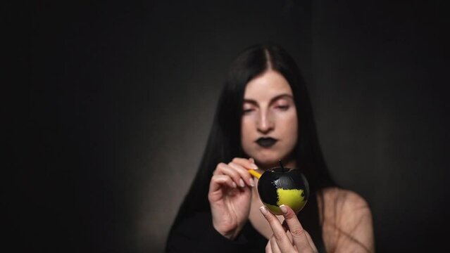 the girl looks at the black apple. the girl wants to spoil the apple.Full HD high-quality video recording