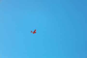 Fototapeta na wymiar Red plane flying in sky