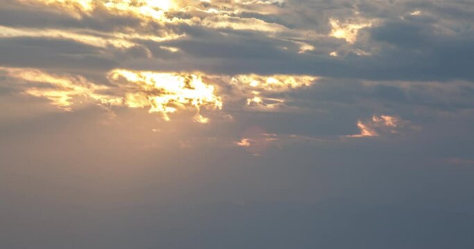 dramatic timelapse as the sun's rays seep through the clouds and illuminate the morning city below
