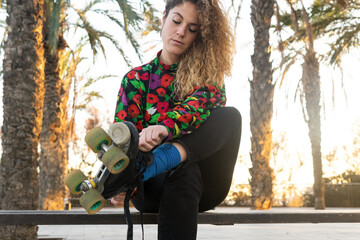 Curly haired woman putting on roller skates