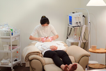 Beautician preparing client face for procedure