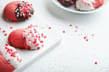 Valentines day cookies. Shortbread cookies with glaze white and dark chocolate and heart sprinkles on white marble stand on white background. Mothers day. Womans day. Sweet holidays baking. Top view.