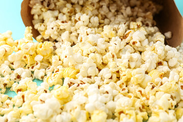 Tasty popcorn scattered on color background, closeup