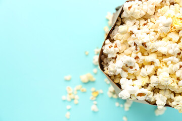 Paper bag with delicious popcorn on color background, closeup