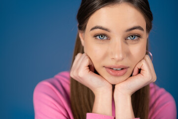 Portrait of teen girl looking at camera isolated on blue.