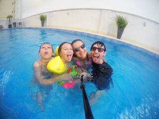 família feliz brincando na piscina de férias 