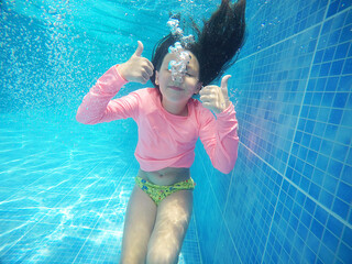 criança feliz em mergulho em piscina 