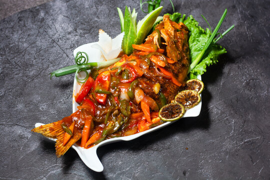 Red Snapper fish hot sauce served in dish isolated on grey background top view of indian and bangladesh food