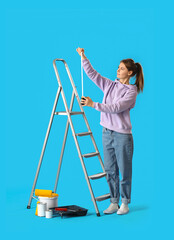 Young woman measuring ladder on blue background