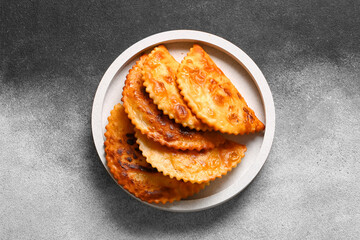 White plate with tasty chebureks on grunge background
