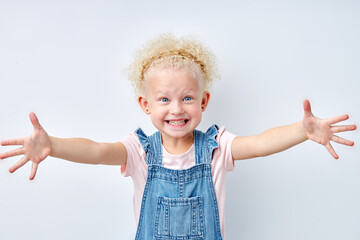 excited expressive emotional blonde girl stretching arms for hug, looking at camera. Blue eyed child girl with curly hair is kind and pleasant. Natural beauty, children human emotions concept