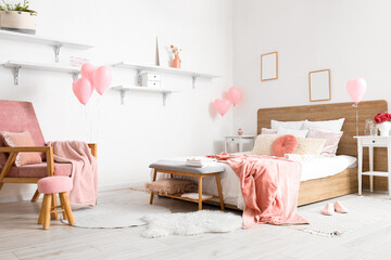 Interior of bedroom with armchair, shelves and pink balloons for Valentine's Day