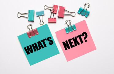 Colorful stickers with WHAT'S NEXT text and multicolored paper clips on a white background