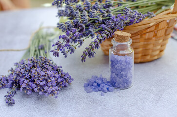Lavender sea salt in a small transparent bottle and fresh lavender flowers