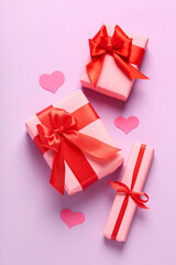 Gift boxes and paper decor on pink background. Valentine's Day celebration