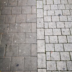 The sidewalk is lined with square gray tiles.