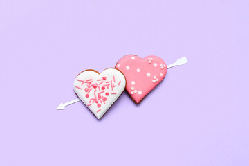 Composition with tasty heart shaped cookies and paper arrow on color background. Valentine's Day celebration