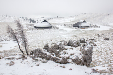 Velika planina mountain 1666 m in Kamnik Savinja Alps in Slovenia, winter hiking in herdsmen’s huts village covered with snow