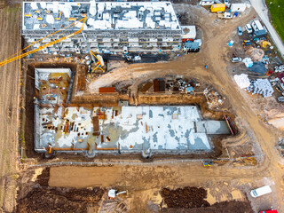 Two new apartment buildings under construction, one almost finished, and other having concrete...