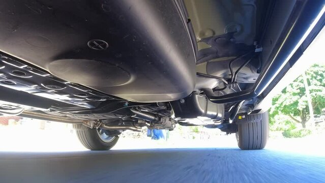 Test drive. View of the car from below. Automobile exhaust system and hoses. All wheel drive trance axle and gas tank with wheels suspension. Pre purchase inspection services, and road service.