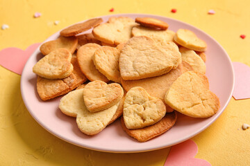 Plate with tasty heart shaped cookies on yellow background, closeup. Valentines Day celebration