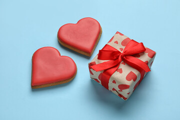 Sweet heart shaped cookies and gift box on color background. Valentines Day celebration