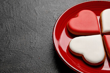 Plate with tasty heart shaped cookies on dark background, closeup. Valentines Day celebration