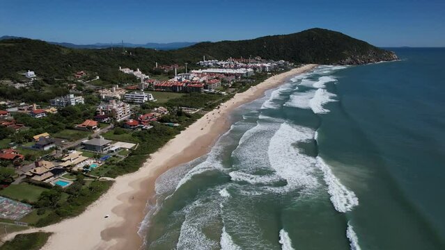 beautiful beach aerial view, drone flying over a beautiful beach on a sunny day with waves, pacific ocean, beautiful beach in the city of florianopolis, brava beach in floripa