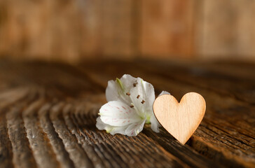 Heart figure and alstroemeria flower on wooden table. Valentines Day celebration