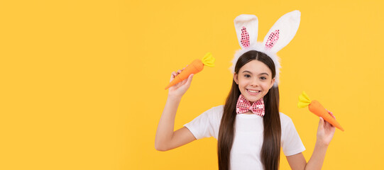 happy easter teen girl in bunny ears and bow tie hold carrot. Easter child horizontal poster. Web banner header of bunny kid, copy space.