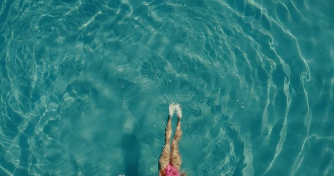 Aerial view of beautiful woman swimming in the the pool at luxury resort spa