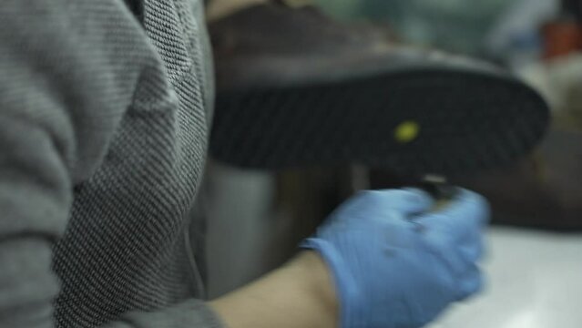 Zapateros latinos latinos con pegamento y herramientas en una fabrica