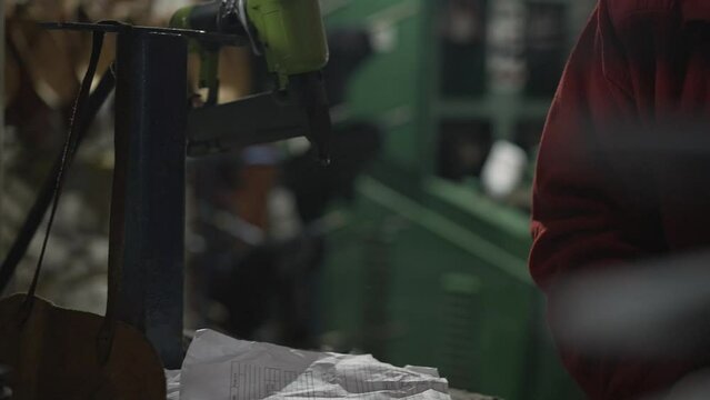 Zapateros latinos latinos con pegamento y herramientas en una fabrica