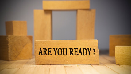 Are you ready text. It is written on a wooden surface. The background is white.
