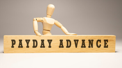 Payday Advance text. It is written on a wooden surface. The background is white.