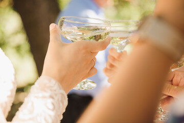 glasses with champagne in the hands of the newlyweds close-up