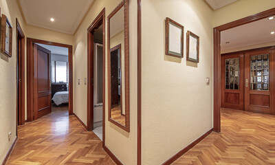 Long distributor corridor of an empty house with oak parquet floors and jatoba wood door carpentry and skirting