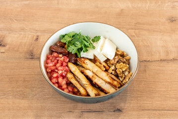A Persian-style salad with grilled chicken, california walnuts, cheese and dates, pomegranate seeds and cilantro