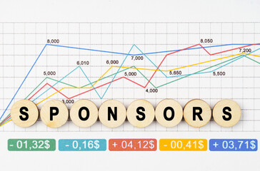 Fototapeta premium On the financial charts are wooden mugs with the inscription - Sponsors