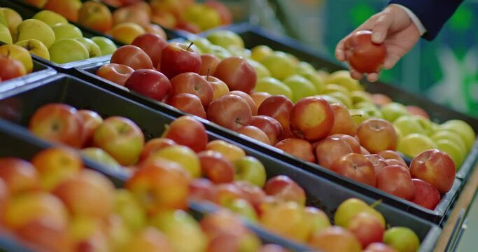 customer taking apples from counter in grocery store, closeup of fruits and hand, 4K, Prores